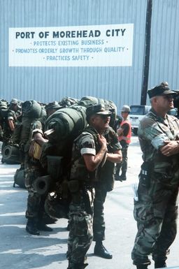 Members of the 8th Communications Battalion prepare to board the amphibious assault ship USS GUAM (LPH-9) prior to the vessel's departure for the Middle East in support of Operation DESERT SHIELD