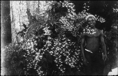 Polian standing beside an orchid, Government House, Rabaul, New Guinea, ca. 1929, 3 / Sarah Chinnery