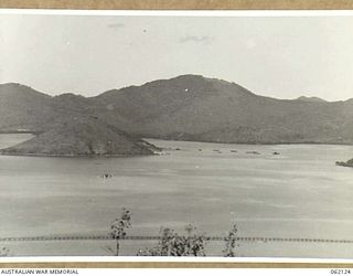 TATANA ISLAND, 1943-12-29. A SECTION OF THE ISLAND AND THE CAUSEWAY LINKING IT WITH THE MAINLAND. IN THE IMMEDIATE FOREGROUND IS THE OIL PIPELINE, WHILE ON THE LEFT CENTRE THE WRECK OF THE ..