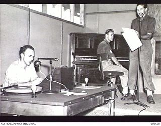 LAE, NEW GUINEA, 1945-12-21. SERGEANT (SGT) C. WATERS (1), SGT D. SIMPSON (2) AND SGT I. J. NEIL (3), BROADCASTING A SESSION IN ONE OF THE STUDIOS OF AUSTRALIAN ARMY AMENITIES SERVICE RADIO STATION ..