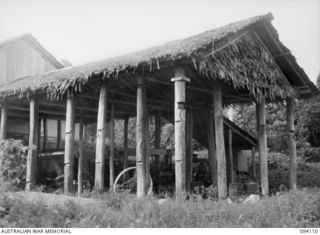 POPONDETTA, NEW GUINEA, 1945-07-02. A COFFEE MILL ON A NATIVE COFFEE PLANTATION. IT HAS BEEN REERECTED AFTER ITS WANTON DESTRUCTION BY THE JAPANESE WHO HAD USED THE SITE AS A HQ