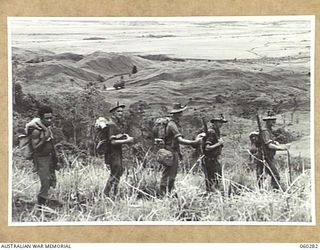 GUY'S POST, FARIA RIVER AREA, NEW GUINEA. 1943-11-08. TROOPS OF THE 2/27TH AUSTRALIAN INFANTRY BATTALION MOVING ALONG A RIDGE BETWEEN GUY'S POST AND THE RAMU VALLEY, DURING THE CHANGE OVER OF THE ..