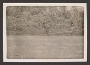 [New Guineans Walking Near Bushes]