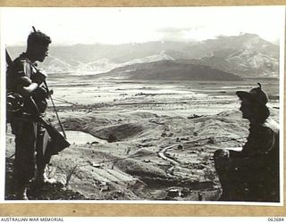 FINISTERRE RANGES, NEW GUINEA. 1943-12-21. NX129759 CORPORAL W. A. CREMOR, 2/27TH AUSTRALIAN INFANTRY BATTALION (LEFT) AND VX68029 TROOPER E. H. HARRIS, 2/6TH AUSTRALIAN CAVALRY (COMMANDO) SQUADRON ..