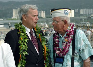 Tom Brokaw (left), NBC Nightly News Anchorman, speaks with Timothy Fitzgerald, Pearl Harbor survivor, at Pearl Harbor, Hawaii, on Dec. 7, 2006, during the joint Navy/National Park Service ceremony commemorating the 65th Anniversary of the attack on Pearl Harbor. More than 1,500 Pearl Harbor survivors, their families and their friends from around the nation joined the more than 2,000 distiguished guests and the general public for the annual Pearl Harbor observance. (U.S. Navy photo by CHIEF Communication SPECIALIST Don Bray) (Released)