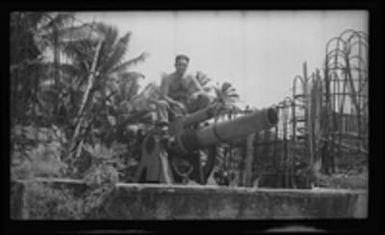 [Elmer A. Ball seated on M1888 coastal artillery gun]