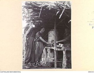 ULEBILUM, NEW GUINEA. 1945-07-13. CAPTAIN TAIT OF THE SALVATION ARMY RED SHIELD (3), AT HIS COFFEE STAFF SERVING COFFEE TO PRIVATE F. MANSELL (1) AND PRIVATE A.R. WILLIAMS (2). THE MEN HAVE BEEN ..