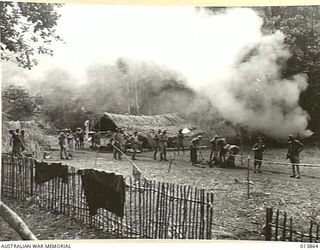 1942-12-17. PAPUA. GONA TRACK. REGIMENTAL AID POSTS ERECTED BY NATIVES ON THE TRACK TO GONA. SMOKE IN THE BACKGROUND IS FROM CAMP FIRES. (NEGATIVE BY BOTTOMLEY)