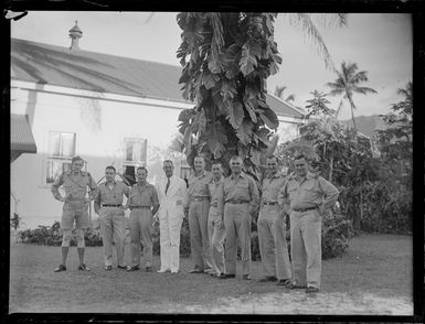 Unidentified RNZAF men, including Mr W Tailby in a white suit, outside a hotel, Rarotonga, Cook Islands
