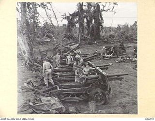 CAPE PUS, WEWAK AREA, NEW GUINEA. 1945-09-07. A LINE UP OF 25-POUNDER GUNS OF NO. 6 BATTERY, 2/3 FIELD REGIMENT ROYAL AUSTRALIAN ARTILLERY. THE BATTERY PERSONNEL ARE CLEANING THE WEAPONS PRIOR TO ..