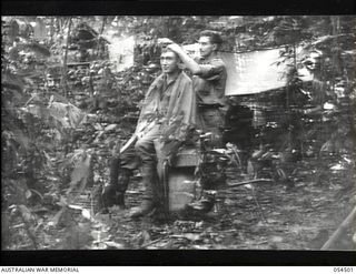 Mubo-Salamaua Area, New Guinea. 1943-07-22. NX81326 Private P. Pilgrim, the 2/5th Australian Infantry Battalion, AIF, barber working on a customer VX9468 Private A. Durose at the Battalion camp ..