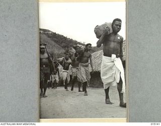 1943-06-28. NEW GUINEA. WAU-MUBO. NATIVE CARRIERS SET OUT ALONG THE TRACK IN THE WAU-MUBO AREA, CARRYING SUPPLIES TO FORWARD AREAS. (NEGATIVE BY G. SHORT)