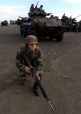 A member of the13th Marine Expenditionary Unit, Camp Pendleton, California, armed with an M-16A2 rifle, secures the perimeter and the Light Armored Vehicles seen behind him with other members of his unit during exercise RIMPAC 98