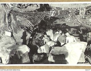 FINISTERRE RANGES, NEW GUINEA. 1944-01-23. PERSONNEL OF NO. 7 BATTERY, 2/4TH FIELD REGIMENT POUNDING JAPANESE POSITIONS WITH 25 POUNDERS IN THE LAKES AREA