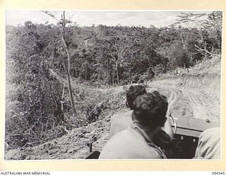 NEWTON'S KNOLL, NEW GUINEA, 1945-07-23. THE ROAD TO YAMIL FROM MAPRIK VIEWED FROM A JEEP MOVING DOWN FROM NEWTON'S KNOLL, INDICATING THE DIFFICULTIES ENCOUNTERED BY ENGINEERS OF 2/14 FIELD COMPANY, ..