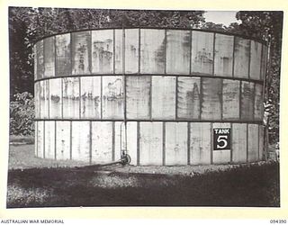 LAE AREA, NEW GUINEA. 1945-07-12. CAPTAIN R.B. CALLAGHAN, LAE BASE SUB-AREA PETROL OIL AND LUBRICANTS (1) WITH MAJOR A.W. YOUNG, OFFICER COMMANDING 2 BULK PETROLEUM STORAGE COMPANY (2), INSPECTING ..