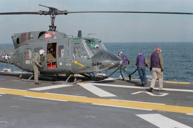 Refueling crewmen refuel a UH-1N Iroquois helicopter aboard the amphibious assault ship USS GUAM (LPH 9)