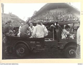 LALUM, BOUGAINVILLE, 1945-06-12. JEEP AND TRAILER OF 19 FIELD AMBULANCE WITH A LOAD OF MEMBERS OF 31/51 INFANTRY BATTALION WALKING WOUNDED. THEY ARE EN ROUTE TO LALUM BEACH FOR TRANSPORT TO THE ..