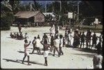 Manus: men playing rugby, referee in striped shirt blows whistle, small group of spectators