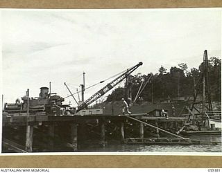 LAE, NEW GUINEA, 1943-11-05. ENGINEERS OF THE 1052ND ENGINEERS PORT CONSTRUCTION AND REPAIR GROUP, UNITED STATES ARMY, WORKING ON THE CONSTRUCTION OF THE FIRST LIBERTY DOCK. SHOWN IS:- ASN-33480320 ..