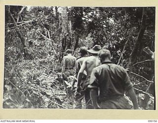 DAGUA, NEW GUINEA. 1945-03-27. A CASUALTY FROM ONE OF OUR OWN MORTAR BOMBS BEING CARRIED OUT BY 2/2 INFANTRY BATTALION STRETCHER BEARERS