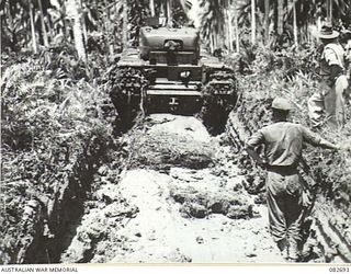 MADANG, NEW GUINEA. 1944-10-12. TRACKS MADE BY A CHURCHILL V TANK DURING TESTS CONDUCTED AT HQ 4 ARMOURED BRIGADE. ACTUAL SIZE IS INDICATED BY THE FIGURE IN THE FOREGROUND