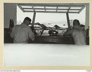 LAE AREA, NEW GUINEA. 1944-11-15. NX54809 CRAFTSMAN F.E. COURT (1) AND QX37796 SERGEANT N. FENNER (2) WORKING IN THE INSTRUMENT SECTION OF THE 2/7TH ADVANCED WORKSHOPS