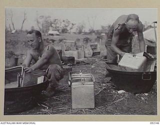 CAPE WOM, WEWAK AREA, NEW GUINEA. 1945-05-09. SERGEANT B.H. HAGEN (1), AND PRIVATE J.W. JOHNSTONE (2), 2/11 INFANTRY BATTALION COOKS, MAKING USE OF CAPTURED JAPANESE RICE BOWLS