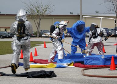 A U.S. Air Force hazardous materials response team AIRMAN, attired in protective suit, goes through a decontamination line after responding to a minor explosion in a warehouse at Andersen Air Force Base (AFB), Guam, on Jan. 12, 2005. The AIRMAN is from the 36th Civil Engineer Squadron here at Andersen AFB. (USAF PHOTO by TECH. SGT. Cecilio Ricardo) (Released)
