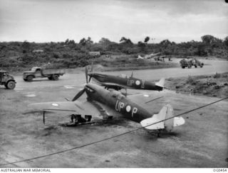 KIRIWINA, TROBRIAND ISLANDS, PAPUA. 1944-01-11. SPITFIRE AIRCRAFT, CODE UP-P, RAAF SERIAL NO. JG807, CODE UP-X, CODE UP-B, OF NO. 79 SQUADRON RAAF ON THE GROUND AWAITING ACTION. NOTE THE WHITE ..