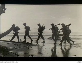 New Guinea. c. 1944. Australian troops pushing along the beach in pursuit of the enemy. They were making their way along the north coast of New Guinea after the occupation of Madang
