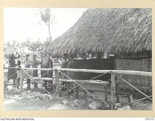 MILILAT, NEW GUINEA. 1944-09-21. PERSONNEL OF THE AUSTRALIAN RED CROSS SOCIETY ATTACHED TO HEADQUARTERS 5TH DIVISION WATCH THE UNLOADING OF SUPPLEMENTARY RATIONS FOR NATIVES IN THE AUSTRALIAN NEW ..