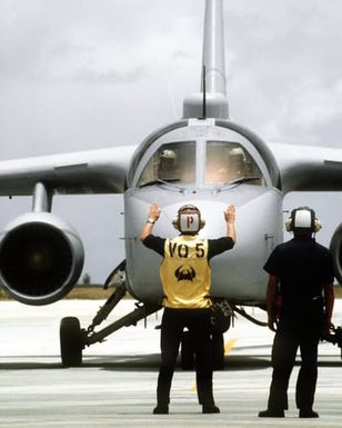 A Fleet Air Reconnaissance Squadron 5 (VQ-5) plane director gives the stop command to the pilot of the Navy's first operational ES-3A Viking aircraft. The aircraft is being delivered to VQ-5