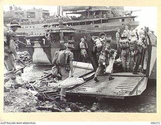 JACQUINOT BAY, NEW BRITAIN. 1945-09-09. TROOPS OF 4 INFANTRY BRIGADE BOARDING BARGES FOR TRANSPORTATION TO HMAS MANOORA. THE MANOORA CARRIED TROOPS FOR THE OCCUPATION OF THE RABAUL AREA, FOLLOWING ..