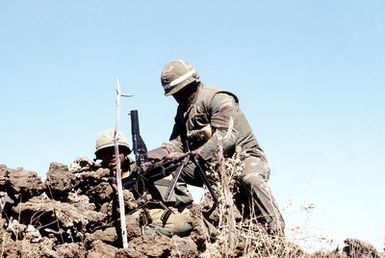 GYSGT Ronald D. Smith, one of the evaluators from Co. C., 1ST Bn., 12th Marines, 3rd Mar. Div., Fleet Marine Force, checks LCPL Richard S. McKinnon's M-60 machine gun, during the battalion's combat readiness evaluation at the Pakalula Training Area