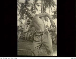 MADANG, NEW GUINEA. C. 1944-10. 79457 CORPORAL H. E. ALLISON, KURANDA, QLD, WINS THE SHOT-PUT WITH A PUTT OF 33 FT 4 INS AT A RAAF SPORTS MEETING AT A FORWARD BASE. ALLISON PLAYED LEAGUE FOOTBALL ..