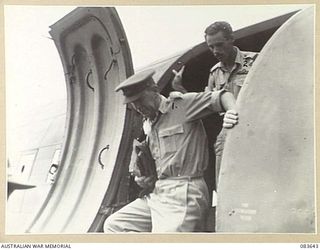 AITAPE, NEW GUINEA. 1944-11-29. MAJOR- GENERAL R H WORDSWORTH, BRITISH ARMY, (1), FOLLOWED BY HIS PILOT, (2), ARRIVES AT TADJI AIRSTRIP DURING HIS TOUR OF HQ 6 DIVISION AND AN INSPECTION OF ..