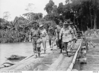 BOUGAINVILLE. 1945-03-26. GENERAL SIR THOMAS BLAMEY, COMMANDER-IN-CHIEF, ALLIED LAND FORCES, SOUTH WEST PACIFIC AREA (5), ACCOMPANIED BY SENIOR OFFICERS, CROSSING THE MCKINNA BRIDGE OVER THE ..