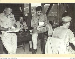 WARD'S DROME, PORT MORESBY, PAPUA, 1944-02. 276015 FLIGHT-LIEUTENANT DONALD CROFT, ROYAL AUSTRALIAN AIR FORCE (1), WITH CAPTAIN JOSEPH S. BREYER (3) OF THE UNITED STATES ARMY AIR CORPS, AT WORK AT ..