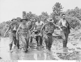 1943-09-22. NEW GUINEA. OUTSIDE LAE. WOUNDED BEING TAKEN TO AN ADVANCED DRESSING STATION OUTSIDE LAE. IDENITIFIED PERSONNEL INCLUDE VX68745 PRIVATE, IAN DOUGLAS CLUTTERBUCK, 2/33RD BATTALION (FAR ..