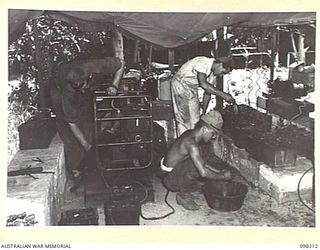 NAMANULA, NEW BRITAIN. 1945-10-19. CRAFTSMAN W.J. WILSON (1) AND CRAFTSMAN J. HOWELL (2), MEMBERS OF 290 LIGHT AID DETACHMENT AT WORK IN THE BATTERY CHARGING ROOM