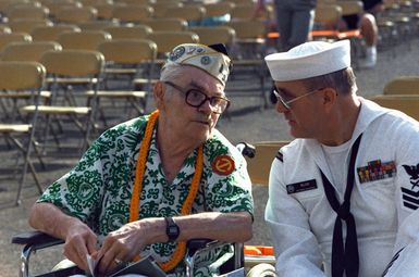 Cryptologic Technician 1ST Class F. Scott Wilson sits beside Raymond Sandlin prior to the start of the Hawaii Remembrance Day observation marking the 50th anniversary of the Japanese attack on Pearl Harbor. Sandlin was an Army private stationed at Hickam Air Field on December 7, 1941