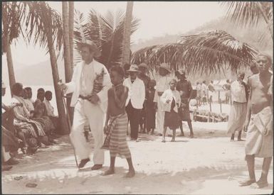 Dr. Welchman walking through villagers gathered for his return to Mara-na-tabu, Solomon Islands, 1906 / J.W. Beattie