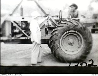 AITAPE, NORTH EAST NEW GUINEA. C. 1944-06. ARTHUR DRAKEFORD, THE MINISTER FOR AIR, TALKING TO THE DRIVER OF A MOBILE CRANE DURING HIS VISIT TO RAAF UNITS IN THE NEW GUINEA AREA