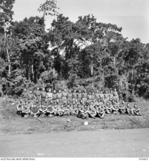 Outdoors group portrait  of fifty seven personnel of the 2/8th Commando Squadron. Identified: Lieutenant (Lt) R Nicholson (1); Lt C A R Starkey (2); Lt D M Astill (3); Corporal (Cpl) J Beattie (4); ..