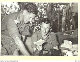 MOTUPINA POINT AREA, BOUGAINVILLE ISLAND. 1945-01-20. TX6233 MAJOR F.J.C. WHITE, BATTERY COMMANDER, NO.6 BATTERY (1) AND VX77483 GUNNER W.C. MAILES (2), CHECKING SIGNALS FROM THE COMMAND POST OF ..