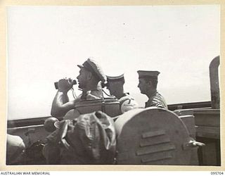 AT SEA OFF RABAUL, NEW BRITAIN. 1945-09-04. SUB-LIEUTENANT L.G. DINNING, OFFICER OF THE WATCH, ABOARD HMAS VENDETTA ON THE LOOKOUT FOR JAPANESE ENVOYS FROM RABAUL, AS THE SHIP PROCEEDS TO A SEA ..