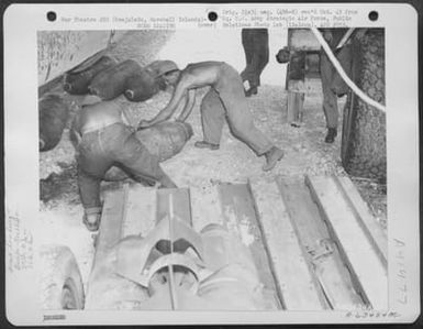 500 Pound Bombs Are Unloaded From Trailer And Placed Beneath A Consolidated B-24 Liberator Of The 27Th Bomb Squadron, 30Th Bomb Group, 7Th Air Force. Kwajalein, Marshall Islands, 7 April 1944. (U.S. Air Force Number A63424AC)