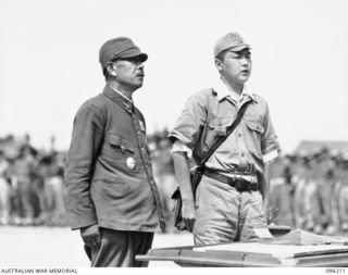 CAPE WOM, NEW GUINEA, 1945-09-13. LIEUTENANT-GENERAL ADACHI, COMMANDER 18 JAPANESE ARMY IN NEW GUINEA, AND INTERPRETER, AT THE TABLE USED FOR THE SIGNING OF THE INSTRUMENT OF SURRENDER. ..