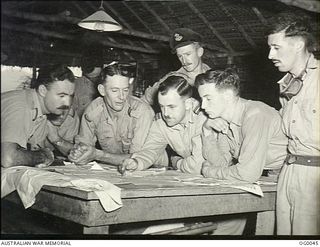 MILNE BAY, PAPUA. 1943-07-22. ON THEIR RETURN FROM A RAID ON JAPANESE INSTALLATIONS AT GASMATA, THE CREW OF A BEAUFORT AIRCRAFT OF NO. 100 SQUADRON RAAF INDICATE "AMENDMENTS" NECESSARY ON THEIR ..